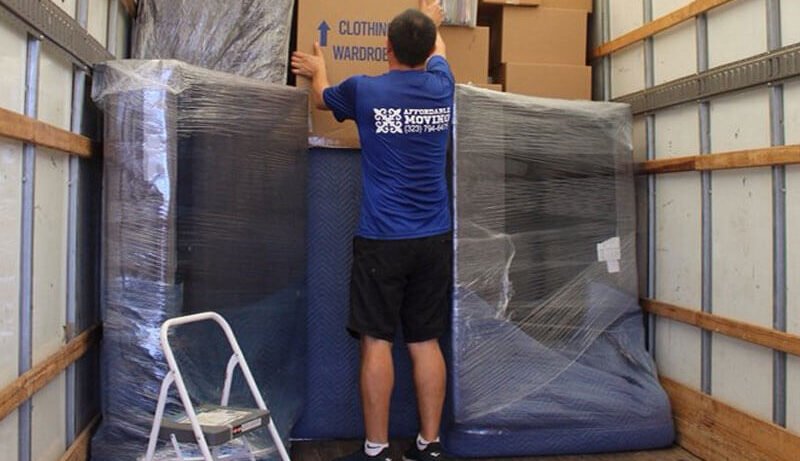 Licensed movers load a two-bedroom apartment for a move.